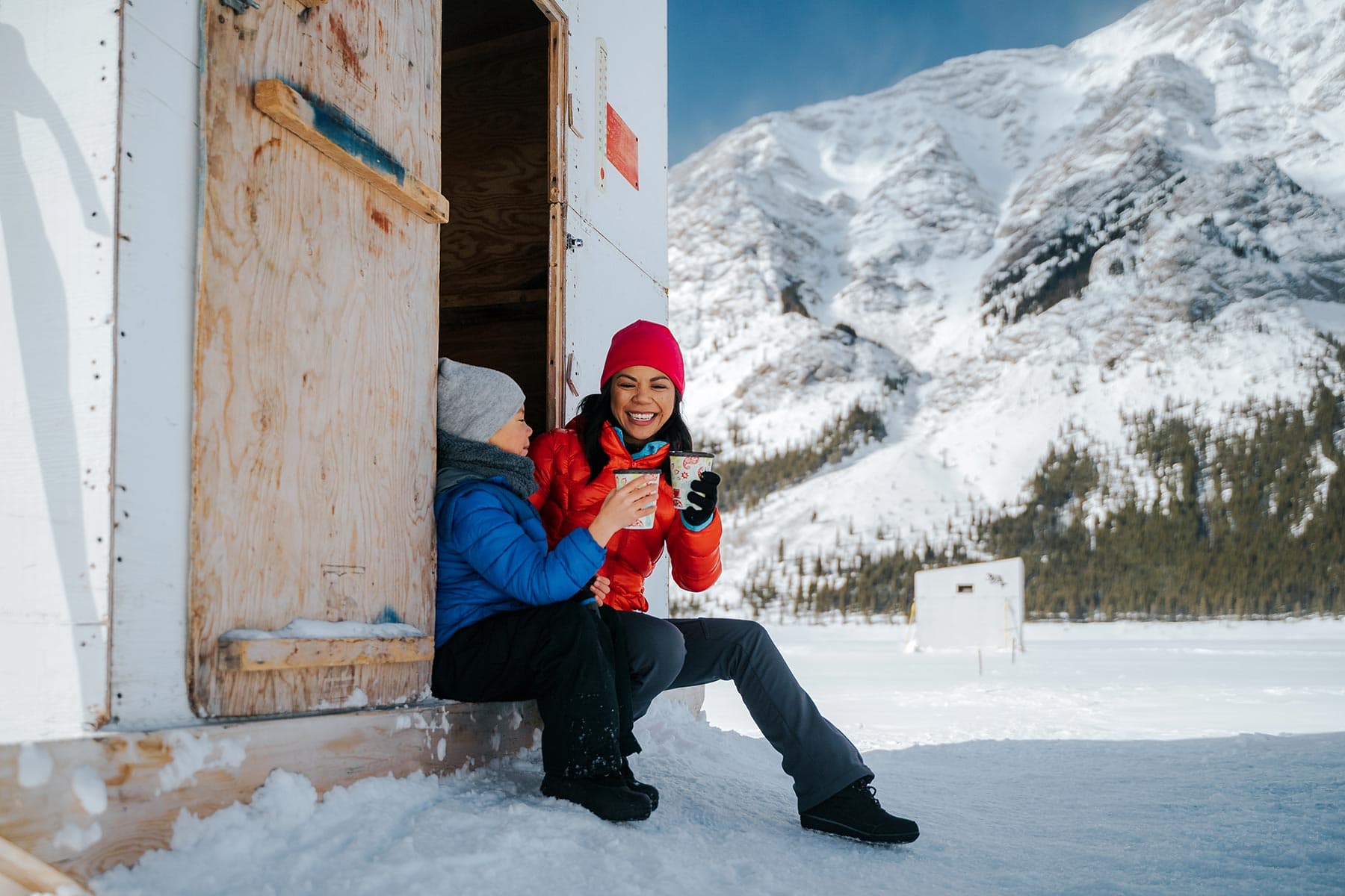 enjoying hot chocolate ice fishing on the spray lakes in winter 